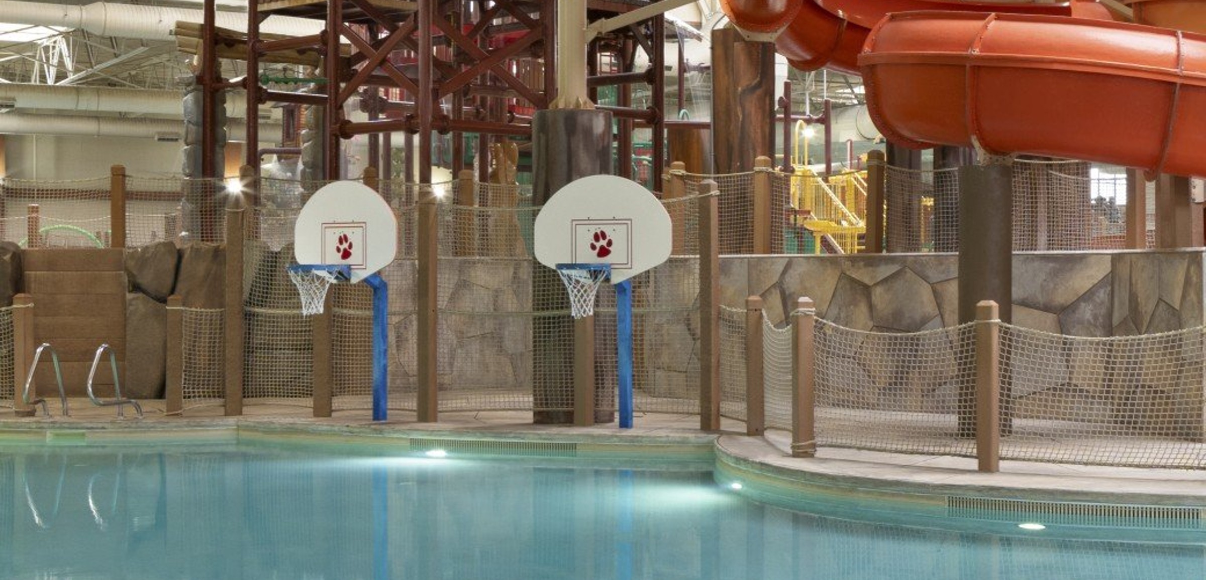 family playing basketball in indoor pool