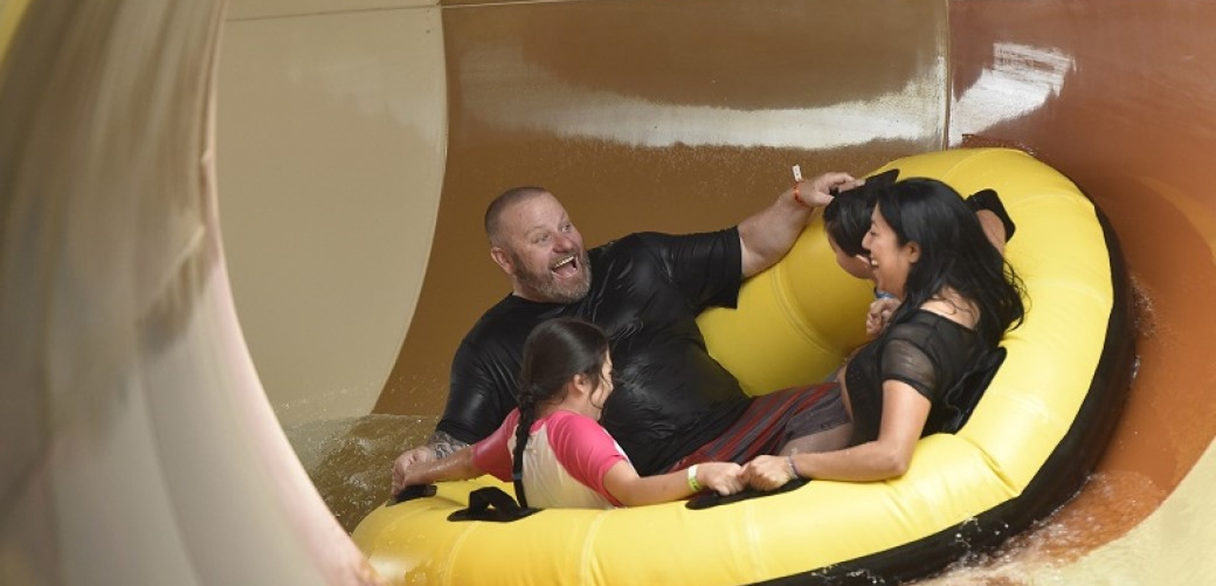 A family rides the Diamond Back Drop water slide
