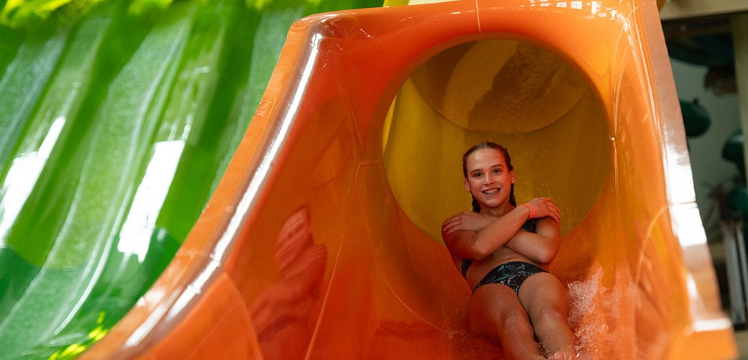 a girl coming down an orange waterslide