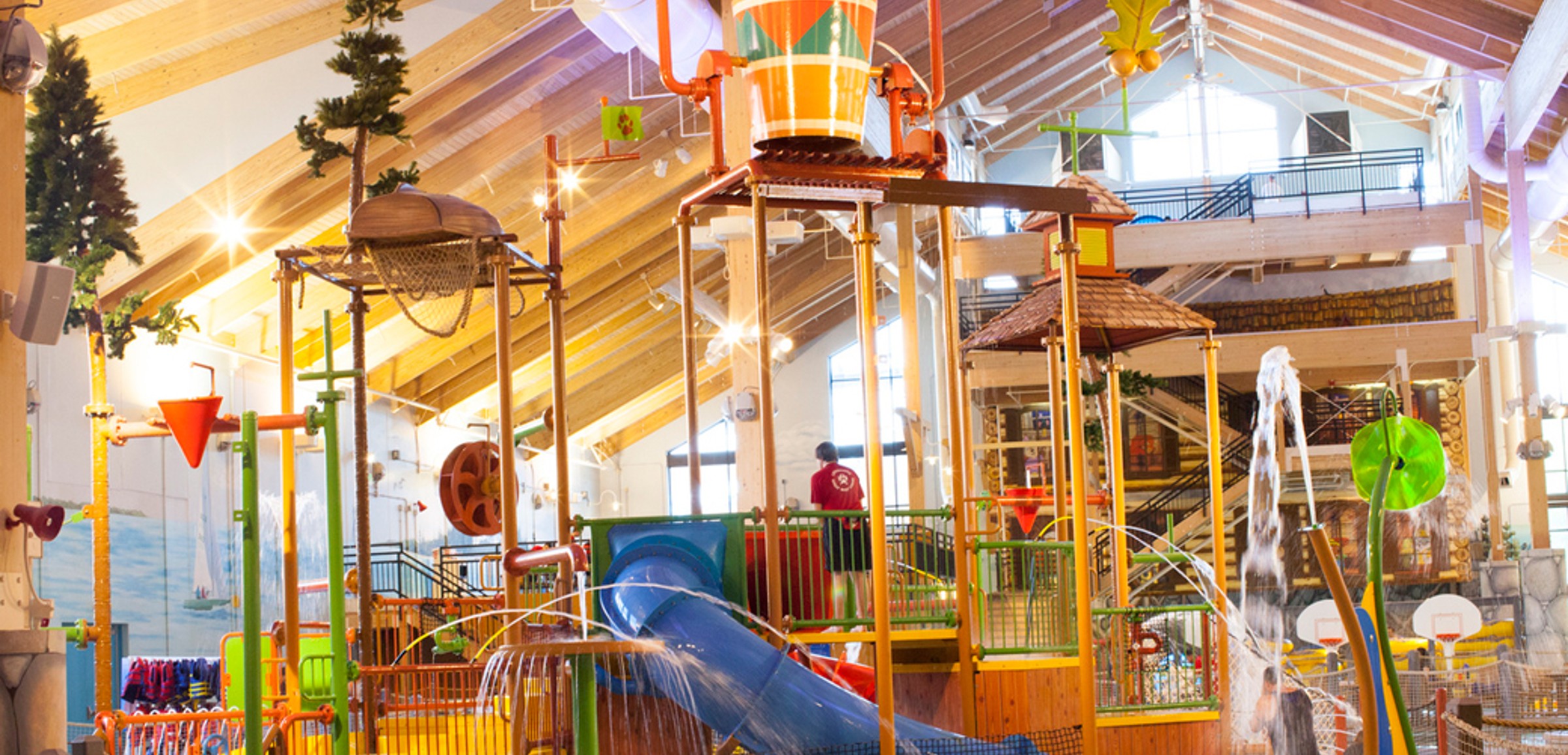 A wide shot of the  water treehouse as water splashes down from a bucket above the jungle gym