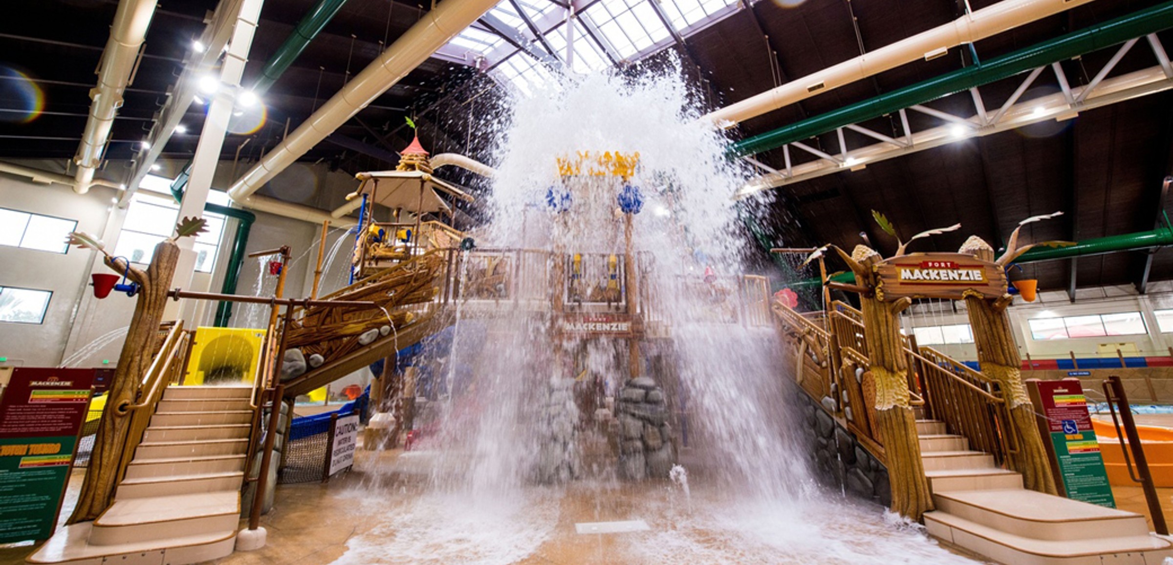 A wide shot of the  water treehouse as water splashes down from a bucket above the jungle gym