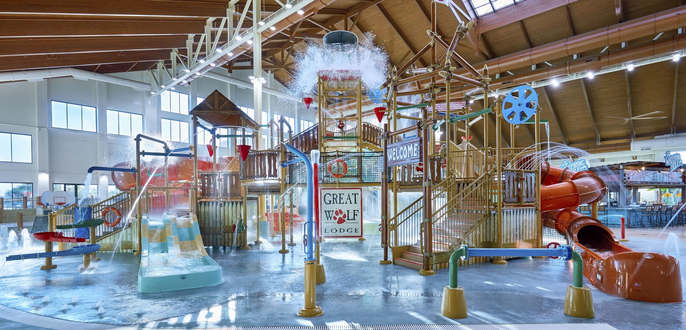 Water bucket splashes water over the top of the stairs and slides of indoor water park