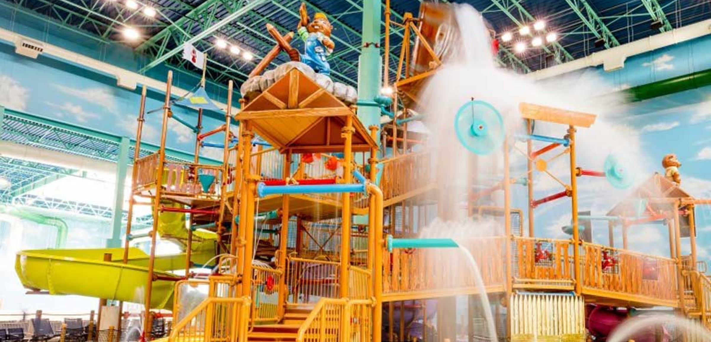 A wide shot of the  water treehouse as water splashes down from a bucket above the jungle gym