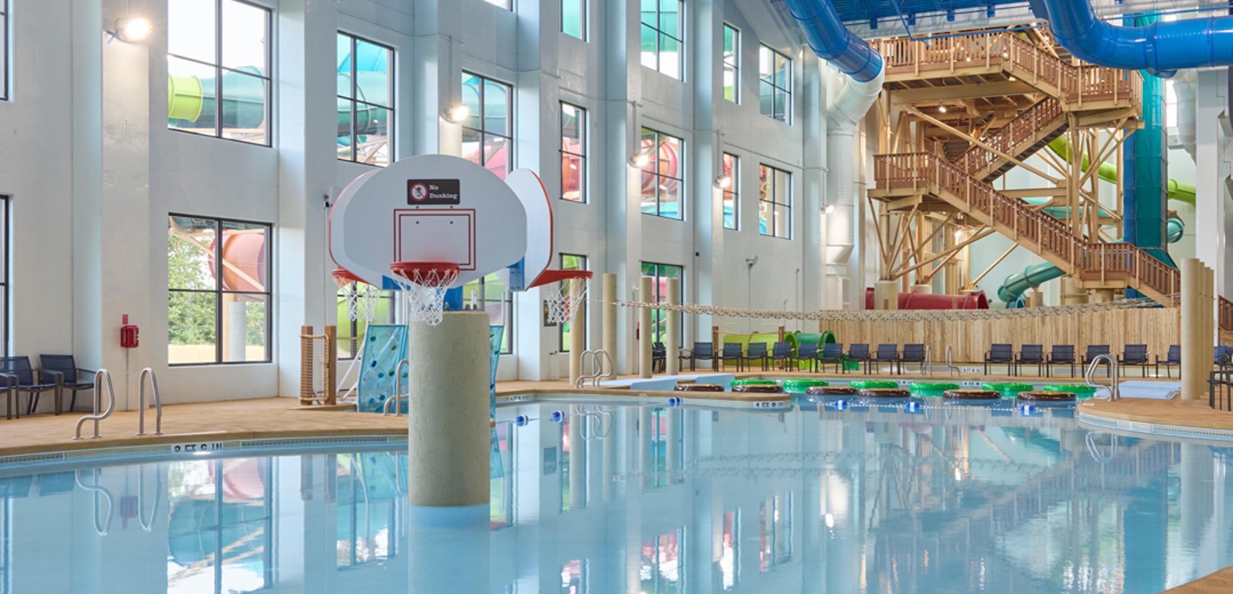 family playing basketball in indoor pool 