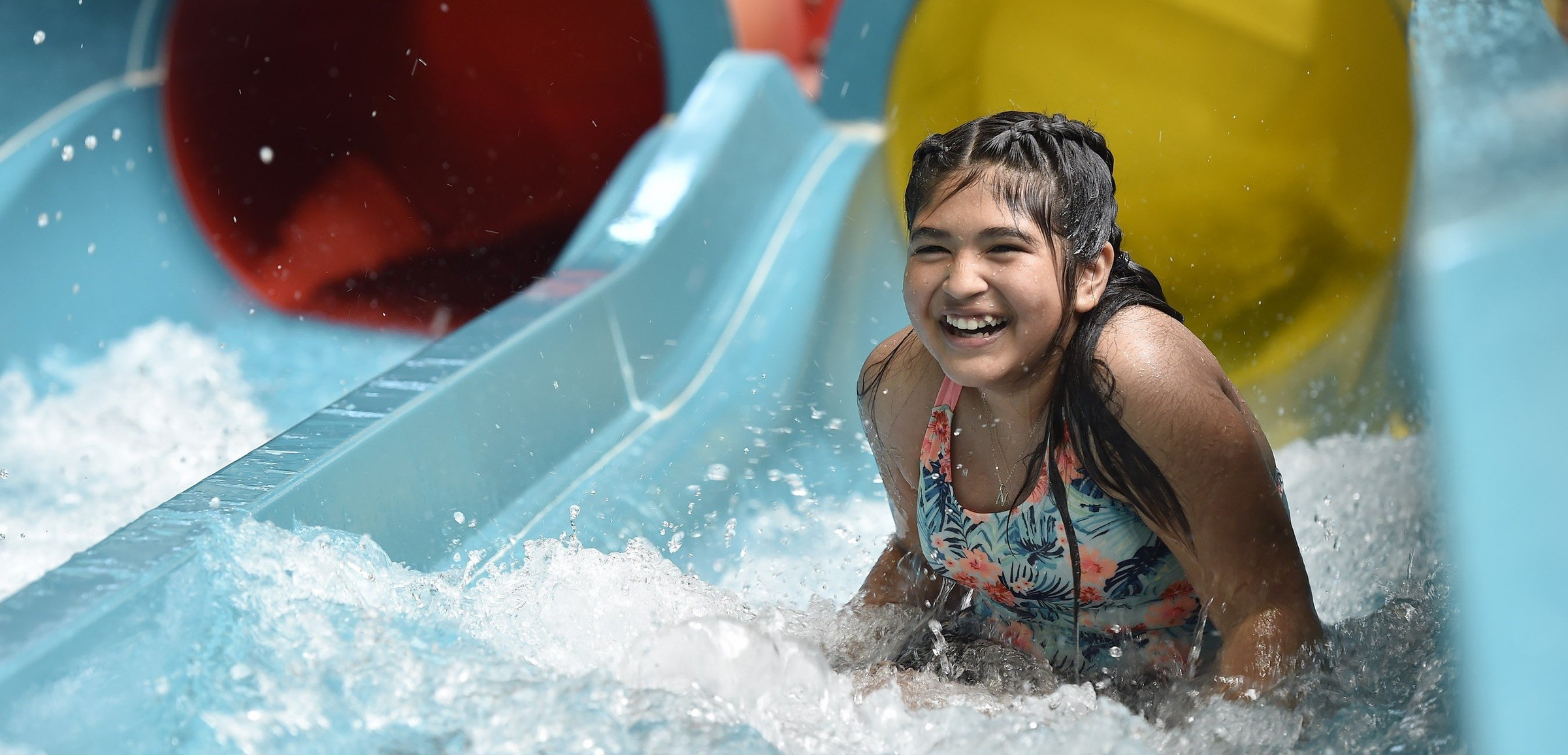 Teen going down a body water slide
