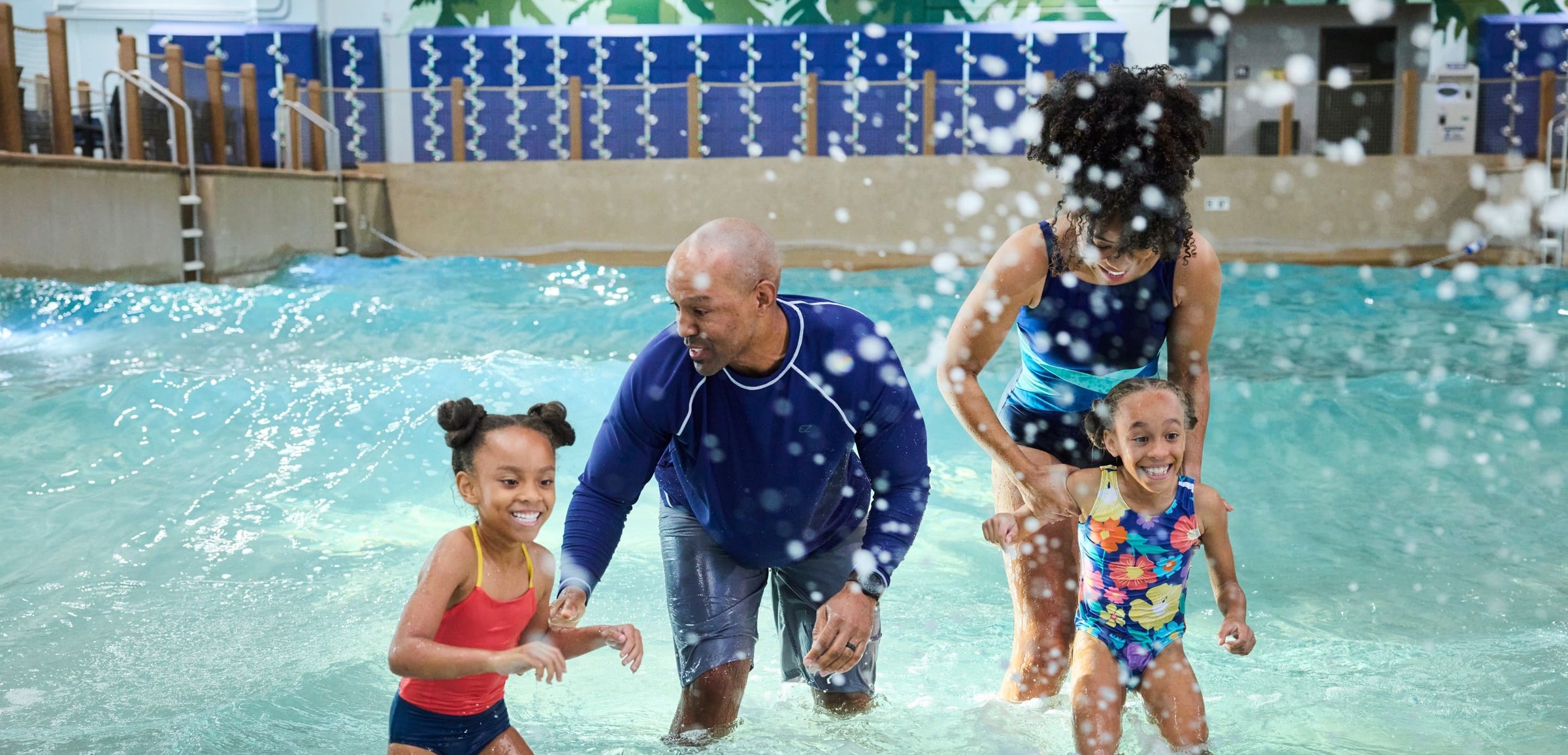 Family of four splashing water in a wave pool