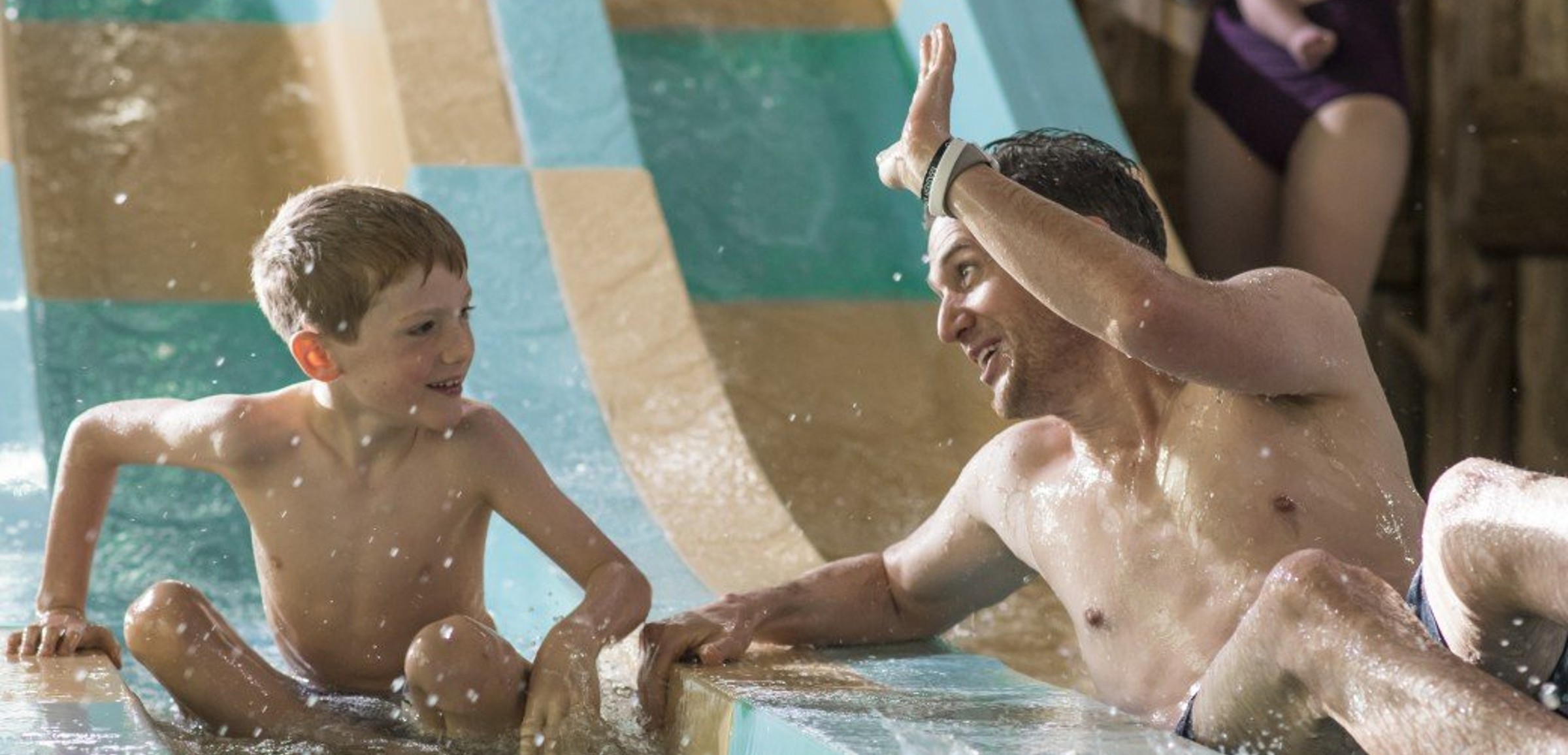 father and son going down a water slide
