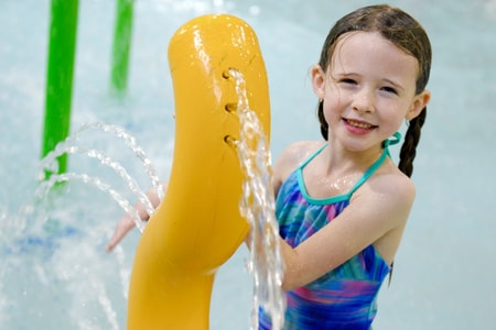 Kids play behind the outdoor water features 