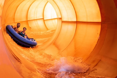 Couple on a blue raft going down a water slide