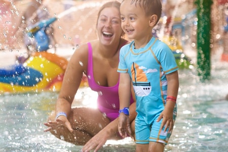 mother and child playing in a kiddie pool