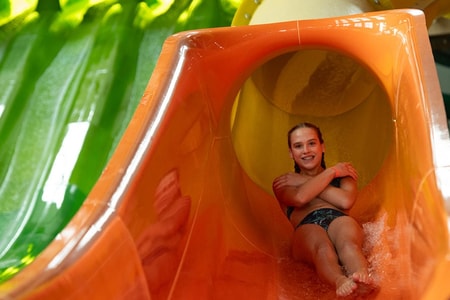 a girl coming down an orange waterslide