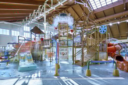 Water bucket splashes water over the top of the stairs and slides of indoor water park