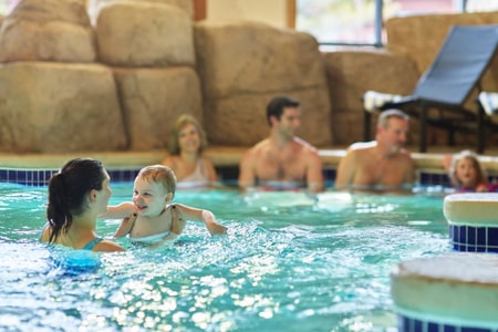 Mother holding baby in a pool 