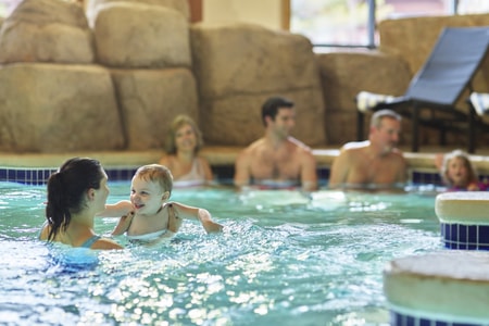 A family relaxes in an indoor hot tub