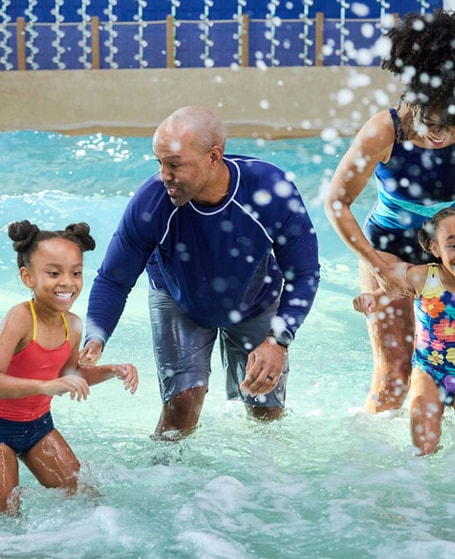 mother and two daughters in a wave pool