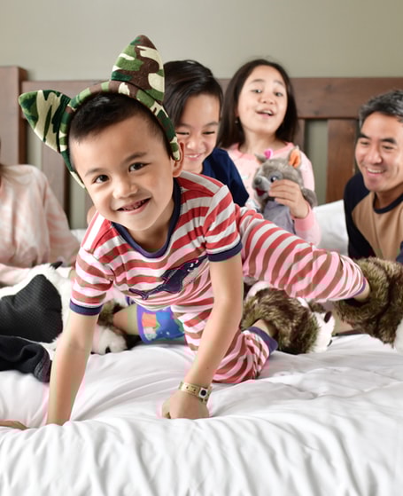 family of 5 sitting on a bed at great wolf lodge