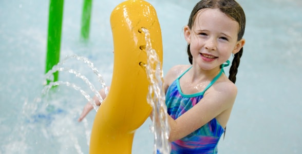 Kids play behind the outdoor water features 