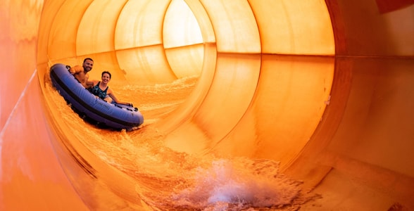 Couple on a blue raft going down a water slide