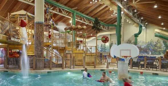 family playing basketball in indoor pool 