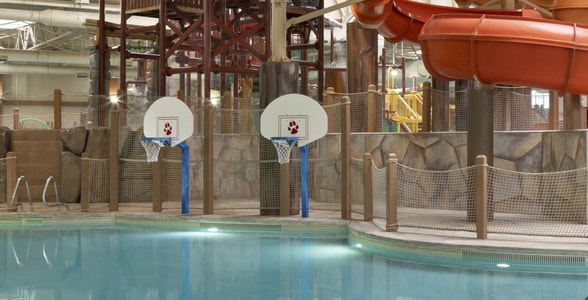 family playing basketball in indoor pool 