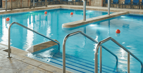  A spacious indoor pool featuring a large slide and multiple water slides for recreational enjoyment.