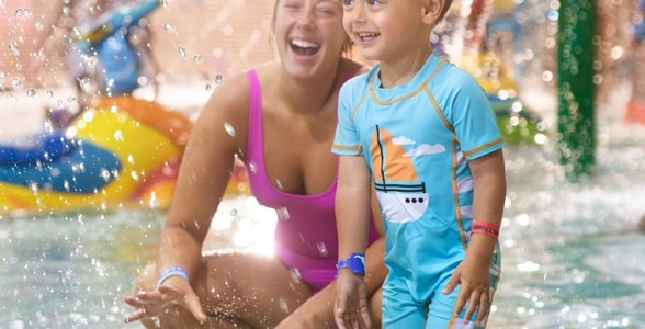mother and child playing in a kiddie pool