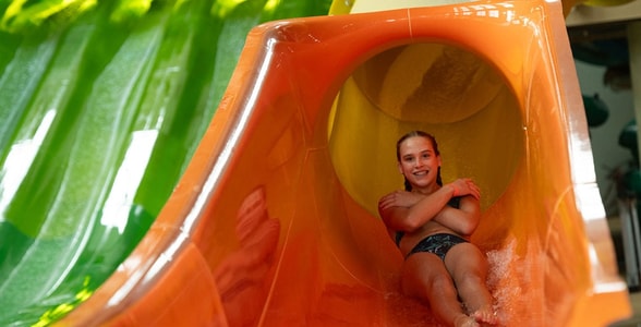 a girl coming down an orange waterslide