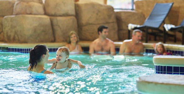 Mother holding baby in a pool 