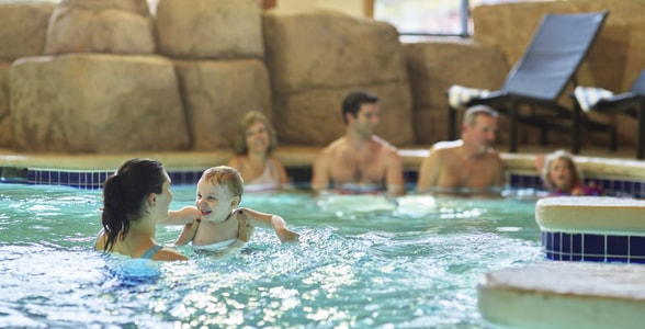 A family relaxes in an indoor hot tub