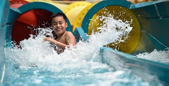 kid rides down waterslide