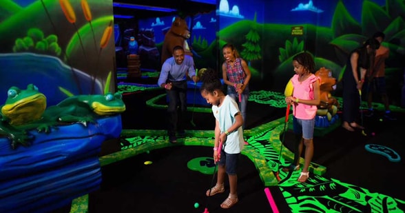 family playing mini glow golf