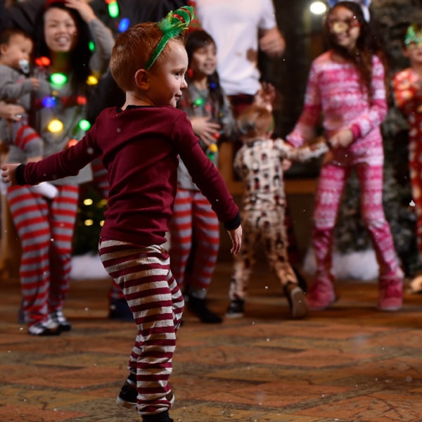 little boy in a holiday pajama dancing 