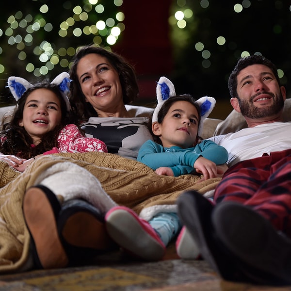 family of five in holiday pajamas watching a movie