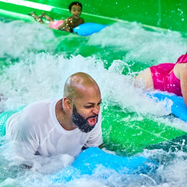 family sliding on a water mat