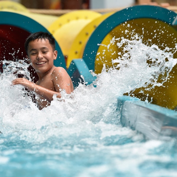 little boy going out of a body slide