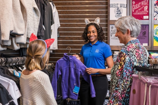 Employee showing customers souvenir options