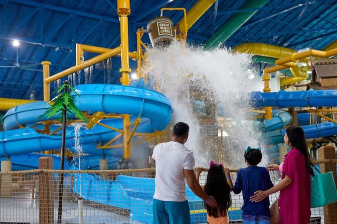 family enjoying water falling from a bucket in a waterpark