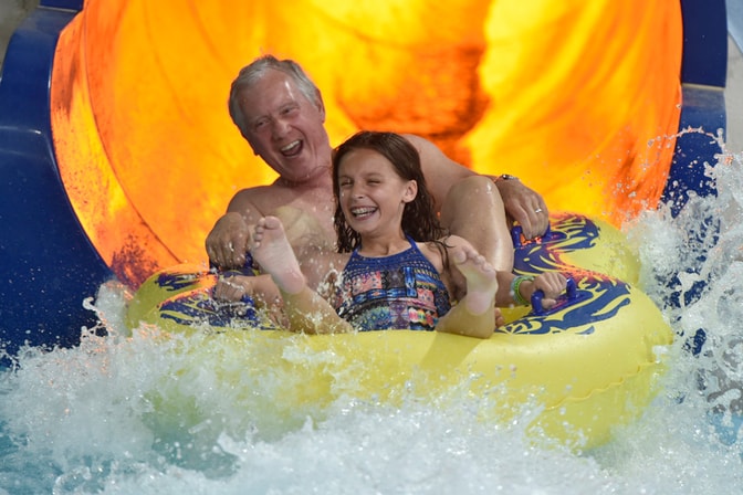 Grandfather and granddaughter on a slide