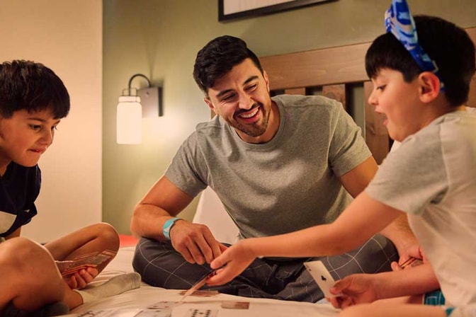 kids playing card game with father