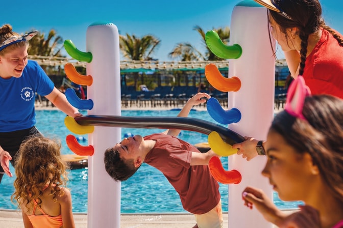 Children playing on colorful pool toy at Great Wolf Lodge.