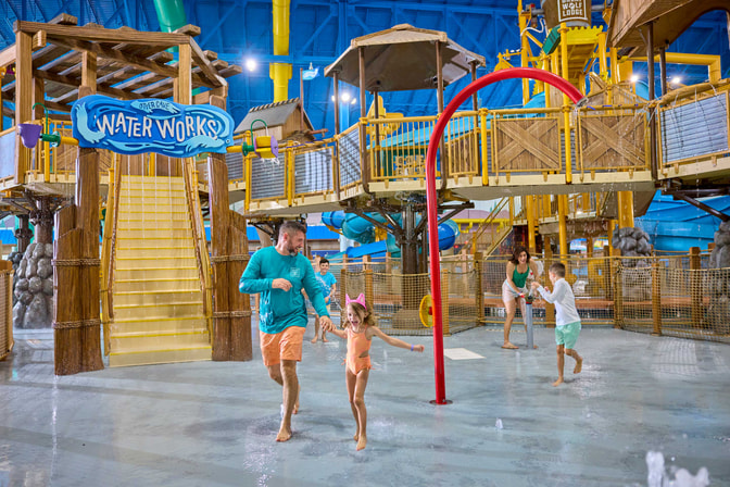 family standing in front of water fort laughing and enjoying