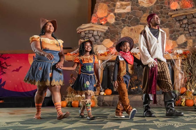 family wearing halloween costumes and walking in lobby