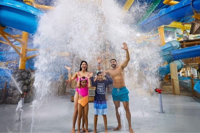 Family of four enjoying the indoor water park at Great Wolf 