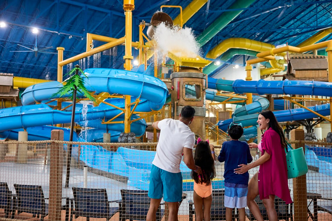 Family viewing indoor water park with colorful blue slides