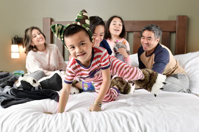 family of 5 sitting on a bed at great wolf lodge