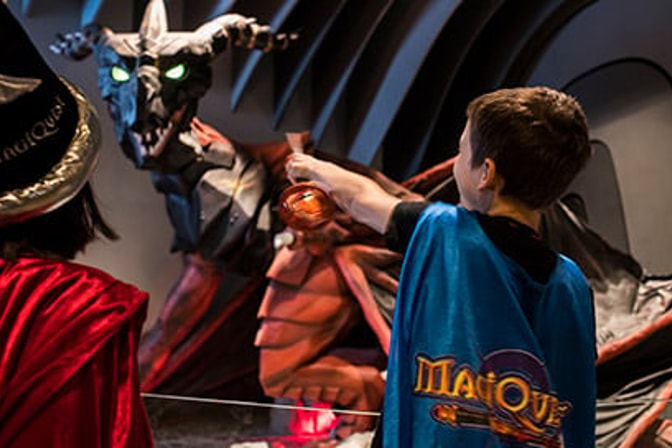 Two kids hold their wands playing MagiQuest