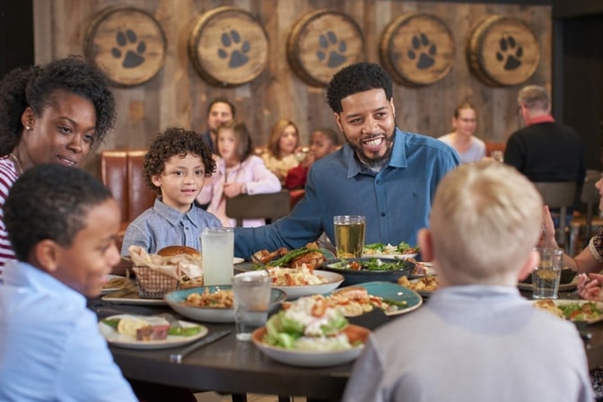 A family enjoy dinner at a Great Wolf Lodge indoor water park and resort restaurant.