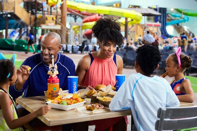 A family enjoys dinner at a Great Wolf Lodge indoor water park and resort restaurant.