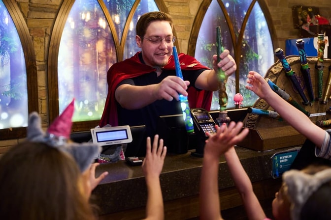 Two kids hold their wands playing MagiQuest