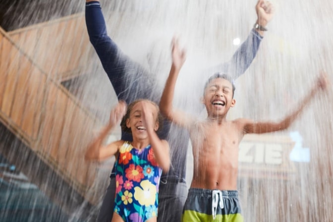 A family of 6 enjoy lunch by the pool at Buckets, an on-site eatery at Great Wolf Lodge.